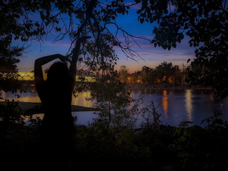 Silhouette standing by the river at night